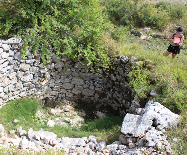 Martina Majetić bilježi izmjeru promjera grla prvoga bunara u gornjem redu skupine bunara Zakope u velebitskoj udolini Vučjak (Foto: Goran Majetić)