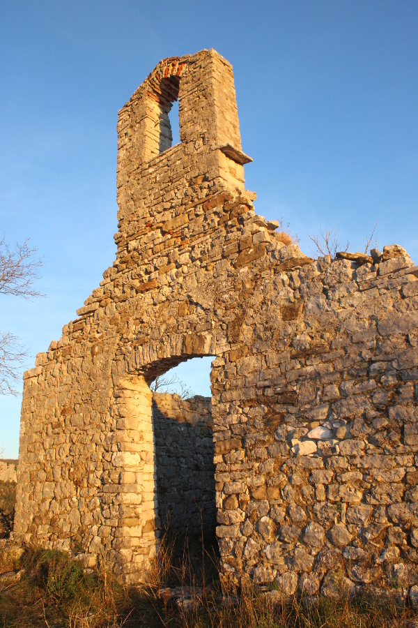 Pogled sa zapada na ulazno pročelje stare kamene crkve na maloj vršnoj zaravni stijene Gorostas, romaničkih obilježja gradnje. (Foto: Goran Majetić)