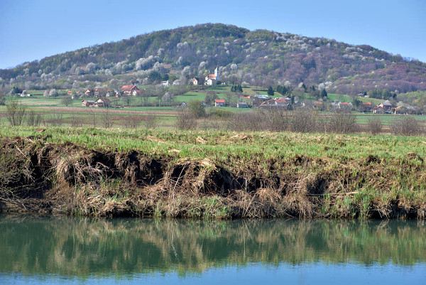 Pogled s istoka na brijeg Martinšćak na čijim padinama je nekoć stajala utvrda Velemerić; u prvom planu vidi se rijeka Korana (Foto: Mario Sečen)
